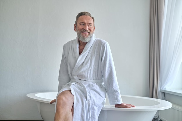 Happy mature man daydreaming in the bathroom