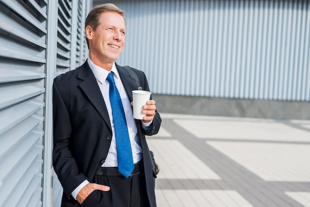 Free Photo happy mature man with cup of coffee at outdoors