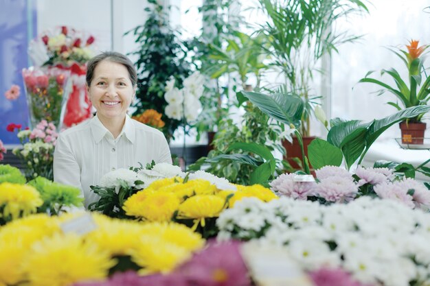 Happy mature woman in  flower shop