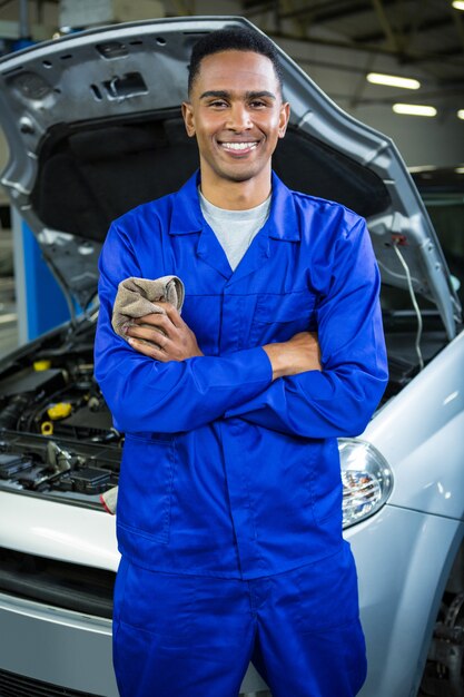 Happy mechanic standing at repair garage