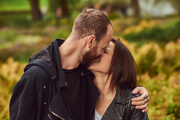 Free photo happy modern couple in the park. enjoying their love and nature.