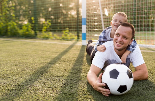 Happy monoparental family leaning on the grass