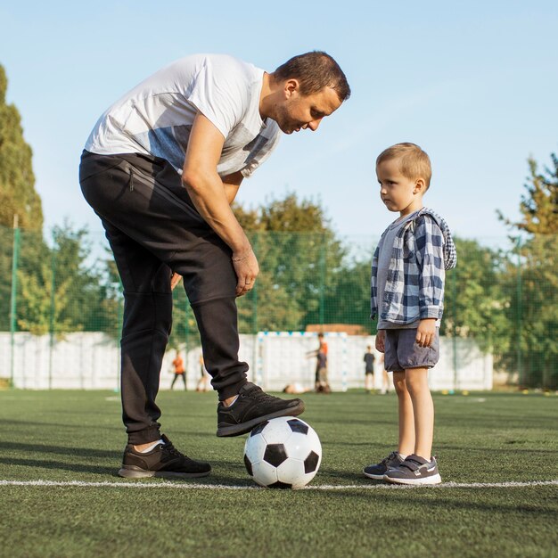 Happy monoparental family learning how to play football