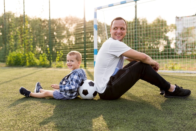 Free photo happy monoparental family sitting on the grass