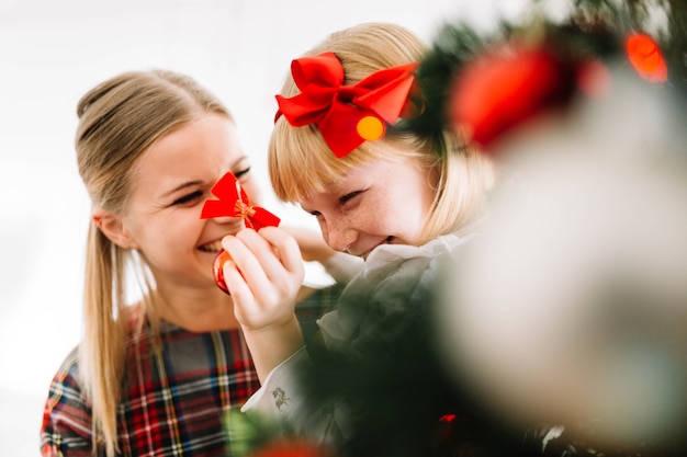 Happy mother and daughter in front of christmas tree