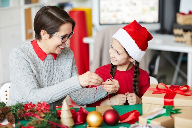 Happy mother and daughter wrapping Christmas presents