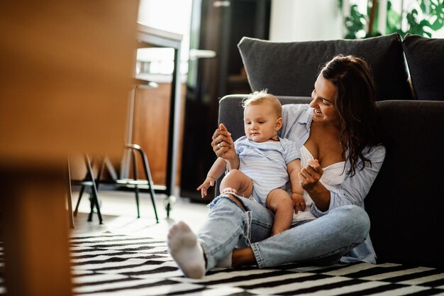 Happy mother enjoying in time she is spending with her baby boy at home