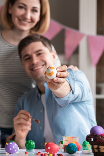 Happy mother and father showing painted eggs for easter