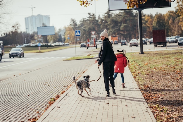 Free Photo happy mother and her daughter walk with dog at the street.