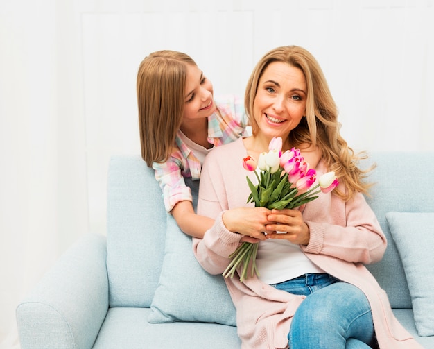 Free photo happy mother with flowers from daughter