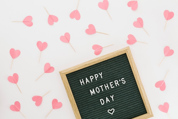 Free photo happy mothers day inscription on board with paper hearts