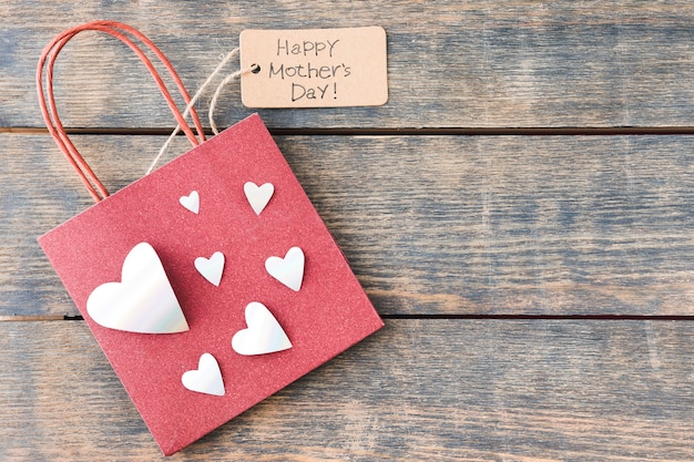 Happy Mothers Day inscription with paper bag and hearts 