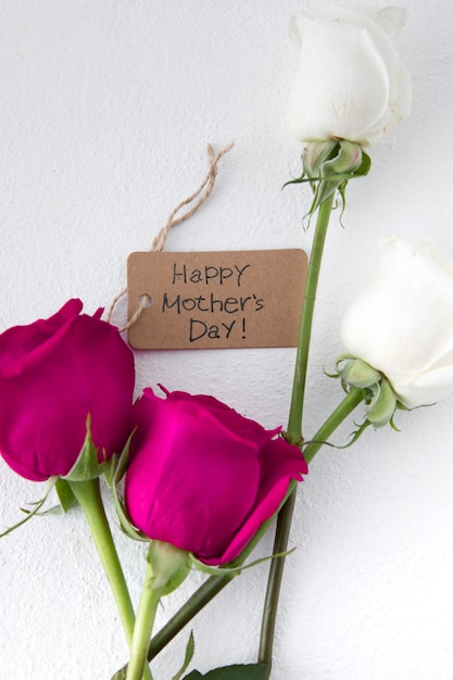 Free photo happy mothers day inscription with roses on light table