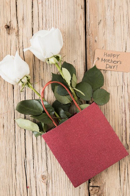 Happy Mothers Day inscription with roses in paper bag