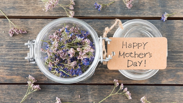 Free photo happy mothers day inscription with small flowers in can