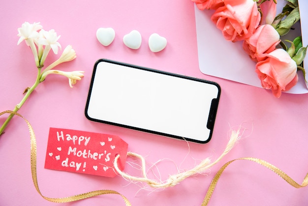 Happy Mothers Day inscription with smartphone and flowers 