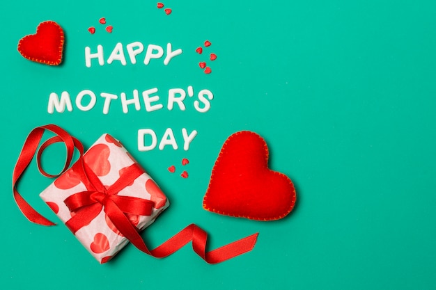 Happy mothers day title near hearts and gift box