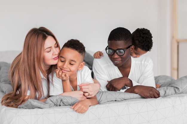 Free photo happy multicultural family staying in bed