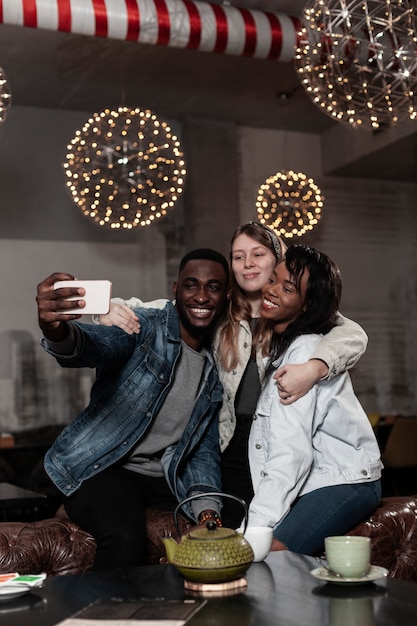 Free photo happy multicultural friends taking selfie