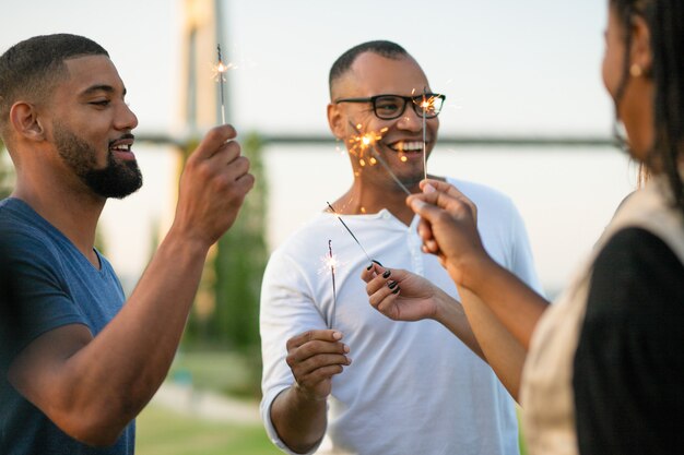 Happy multiethnic friends with sparklers