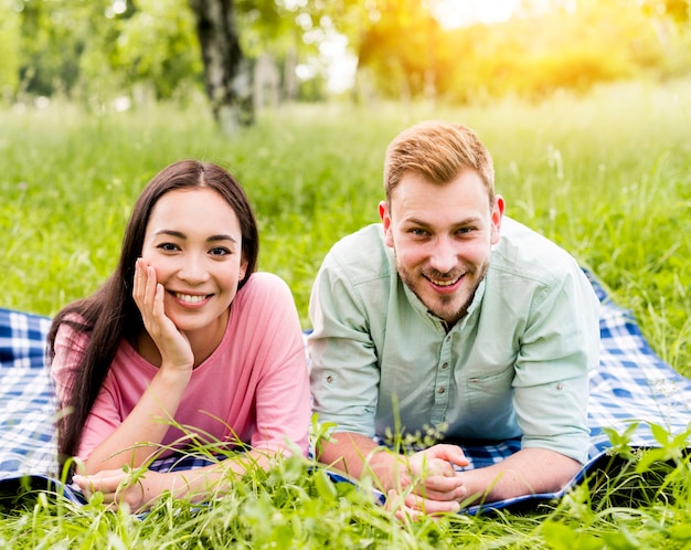 Happy multiracial couple posing on picnic