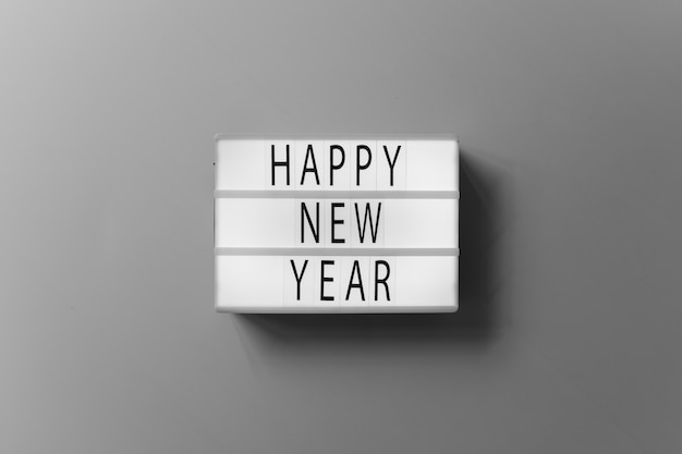 Free photo happy new year inscription on white board on table