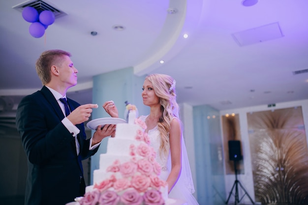 Free photo happy newlyweds eating wedding cake