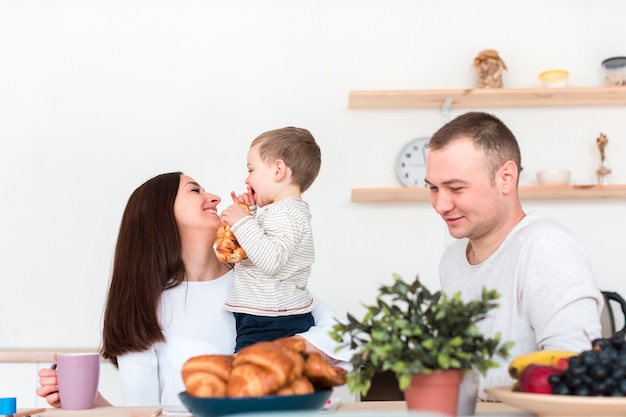 Happy parents holding child in the kitchen