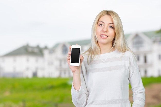 Happy pretty woman showing a blank smart phone screen