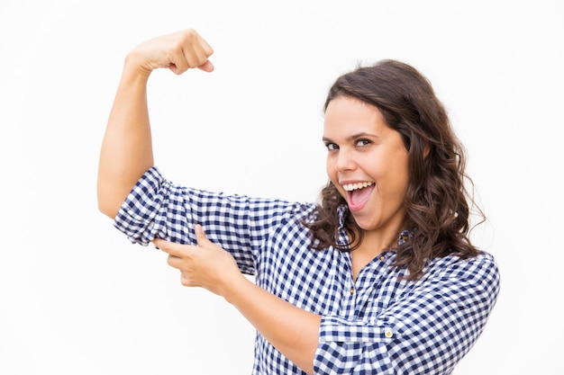 Free Photo happy proud woman showing bicep and smiling with open mouth