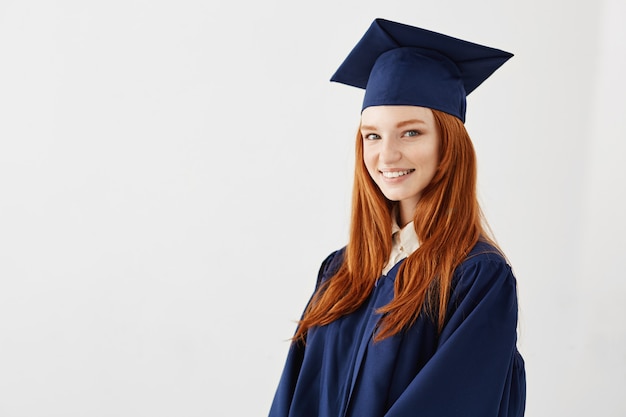 Happy redhead female graduate smiling. 