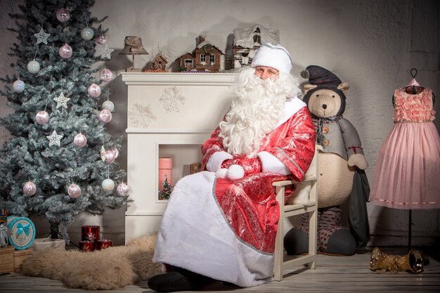 Happy Santa Claus sitting on on the of Christmas decorations