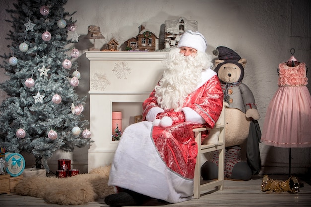 Happy Santa Claus sitting on on the of Christmas decorations