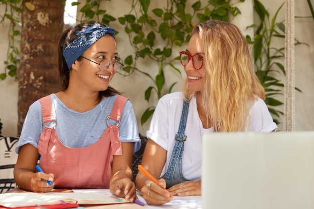 Happy satisfied smiling teenage college student hold pens, prepare for writing course paper