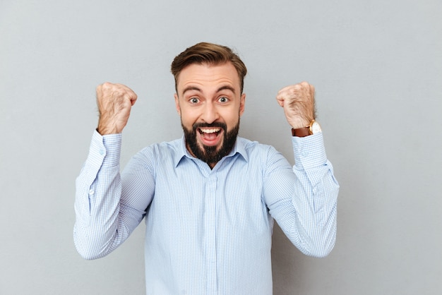 Happy screaming bearded man in business clothes looking at camera