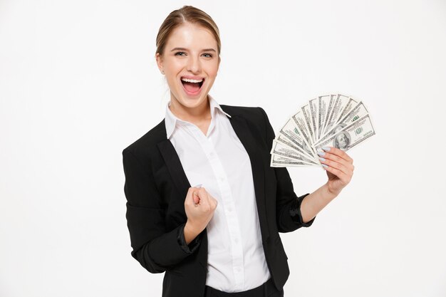 Happy screaming blonde business woman holding money and  over white wall