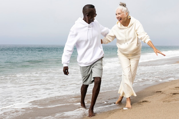 Happy senior couple relaxing at the beach in winter