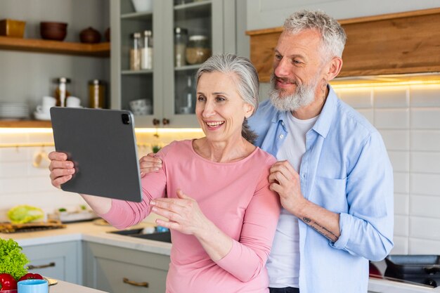 Happy senior couple with tablet medium shot