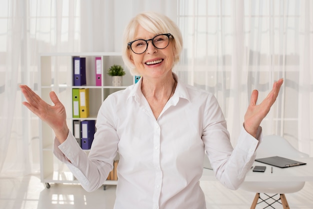 Happy senior in her office medium shot