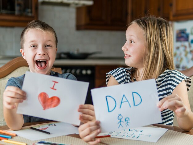 Happy siblings drawing for their father