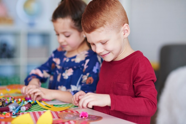 Free photo happy siblings preparing decorations for easter time