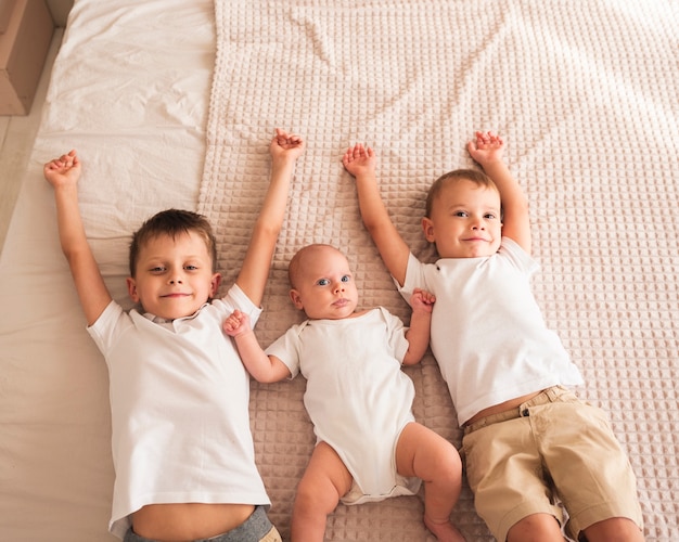 Happy siblings with new born baby