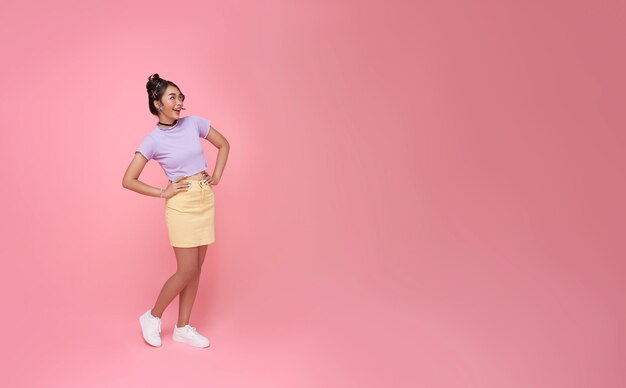 Happy smile Asian woman standing looking away to side with smile on face to isolated on pink copy space studio backgroundxA