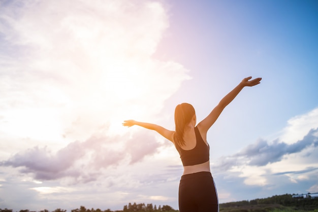 Happy smiling athletic woman with arms outstretched 