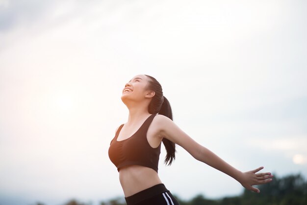 Happy smiling athletic woman with arms outstretched 