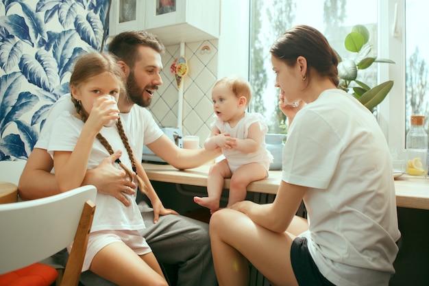 Free Photo the happy smiling caucasian family in the kitchen preparing breakfast