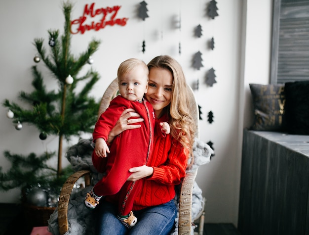 Happy smiling family at studio on background of the Christmas tree with gift