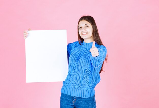 happy smiling girl with white blank board showing a thumb up.