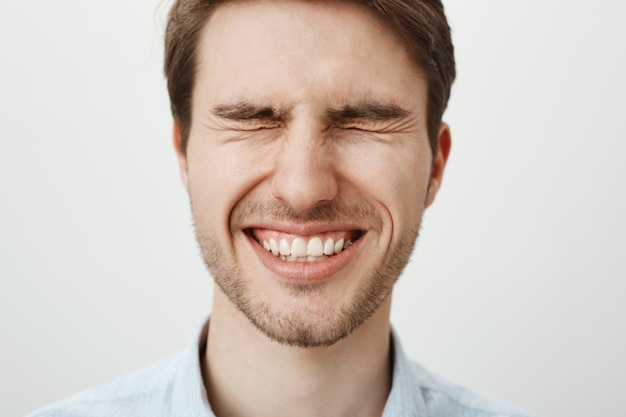 Happy smiling handsome man with closed eyes