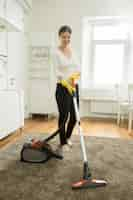 Free photo happy smiling woman cleaning the carpet